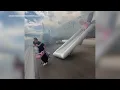American Airlines passengers exit plane via emergency slide after aborted takeoff in Denver