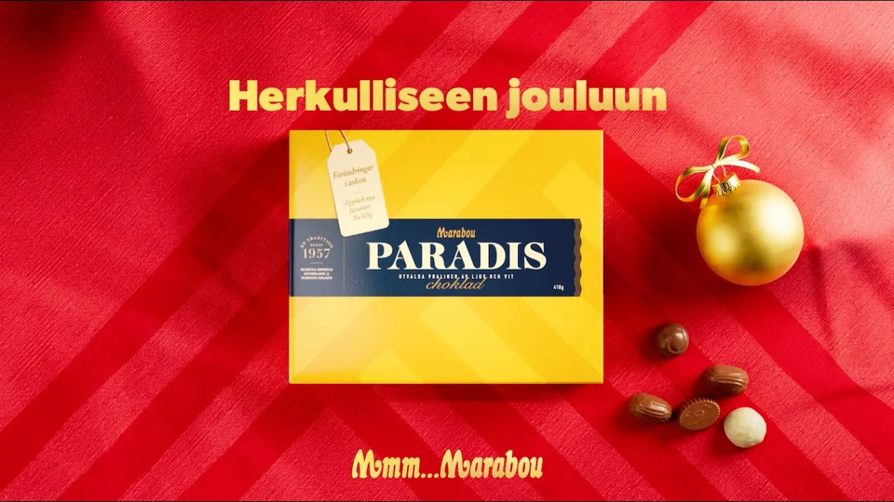 The ad opens with a close-up of a yellow Marabou Paradis chocolate box on a red, striped background. A gift tag is attached…