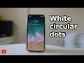 White circular dots on the upper left corner of the iPhone