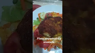 Filete empanizado de pescado y ensalada.