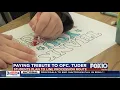 Students make signs for Tuder funeral procession