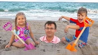 diana and roma play with dad on the beach