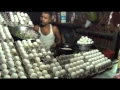 Man cooking Egg Omelette and giving it to customer on bread