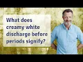 What does creamy white discharge before periods signify