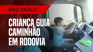 Criança guia caminhão em rodovia
