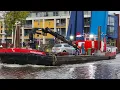Tug MERWESTREEK from Belgium. Work vessel. Old barge with a crane. The ship passes the Dutch bridge.