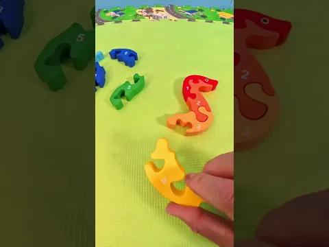 Fitting Wooden Snake Puzzle Blocks Into Place On A Play Mat For Young Children