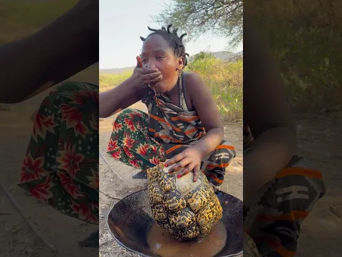 Hadzabe queen enjoying eating roasted tortoise meat