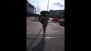 WOMAN WALKS ACROSS IN ADORABLE PANTS AND BACKPACK ACTIVE WOMEN SERIES 