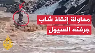فيضانات ليبيا محاولة إنقاذ شاب جرفته السيول في مدينة درنة 