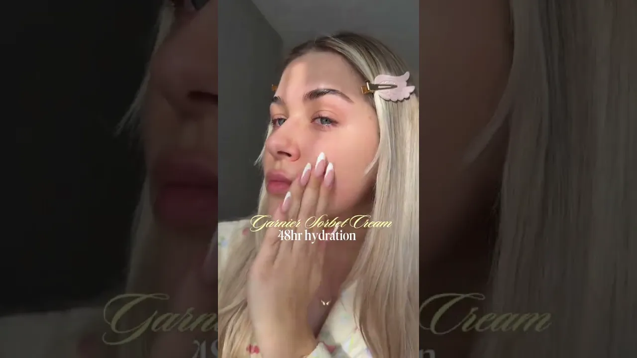 A person applies Garnier Vitamin C Glow Booster Sorbet Cream, 85 ml, to their face.