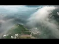 Drone of rolling fog and low lying clouds over beautiful evergreen mountain ranges