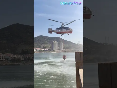 The bucket water collection operation of a fire-fighting helicopter on the lake