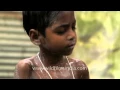 Indian woman bathes her child in an open place before school