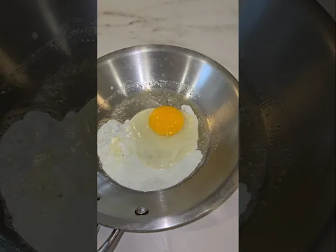 Counter top fried egg on a stainless steel pan