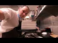 THE DISHWASHER HAS LOTS OF HOT CLEAN PLATES TO STOCK IN RESTAURANT KITCHEN MINIMUM WAGE WORK