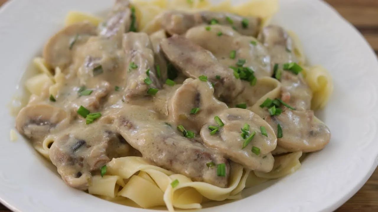 Beef Stroganoff or Beef Stroganov, a Russian dish consisting of sautéed pieces of beef served in a m. 