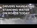 Drivers navigate heavy rain standing water across Portland