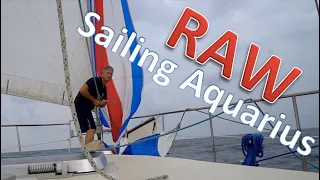 Ken pulling up ballooner sail while on passage in Indonesia / Sailing Aquarius RAW