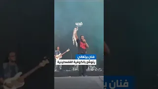 الفنان البرتغالي دينو دي سانتياغو يتوش ح بالكوفية الفلسطينية في مهرجان بروكسل تضامن ا مع غزة 