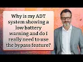 Why is my ADT system showing a low battery warning and do I really need to use the bypass feature