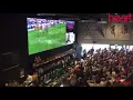 Fans in a bar cheering at soccer goal reaction