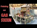 Finishing our gas station on a pier for our model railroad layout