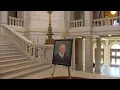 State house rotunda displaying Caprio portrait public condolence book