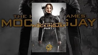 Jennifer Lawrence as Katniss Everdeen standing in the ruins of District 12 in the poster for The Hunger Games: Mockingjay Part 1 game.