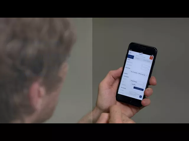 Човек, използващ смартфон с приложение в ръка, работещ с интерфейс на мобилно устройство.