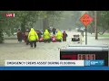 Emergency crews work to help people evacuate from Ravenswood along White River