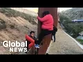 Migrant families continue to spill over Tijuana border fence head to U S