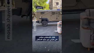 غير مكترث طفل فلسطيني يجلس بثبات بين جنود الاحتلال خلال اقتحام الخليل 