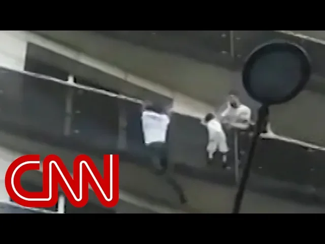 Man scales building to save dangling child