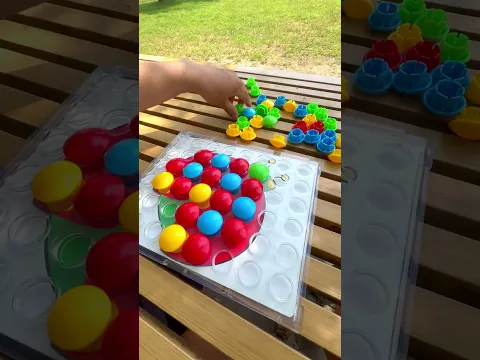 Sticking colorful peg pieces onto a ladybug design outside