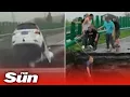 Car PLUNGES into crater after driving off collapsed bridge amid severe weather in China