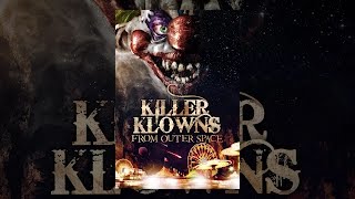 A giant killer klown looms over a theme park on the poster for Killer Klowns from Outer Space (1988).