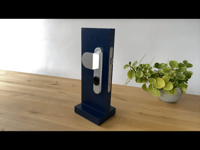 Брава за врата хром LOQED Touch Smart Lock 2S - 073909, SHELLY, LOQED Touch Smart Lock 2S S на дървена повърхност.