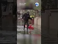 Neighbors kayak through street flooding in Long Beach