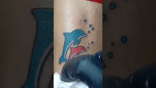 a cute dolphin couple tattoo with color