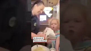 فتاة صغيرة تطلب من النادل أن يسكب الجبن المبشور مباشرة في فمها دندنها