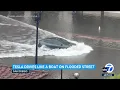 Tesla car plows through flooded San Diego street