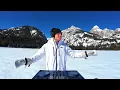 melodic house dj set on a frozen lake surrounded by mountains