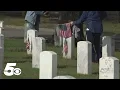 Volunteers pick up flags at Fort Smith National Cemetery