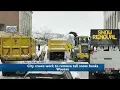 city crews work to remove tall snow banks