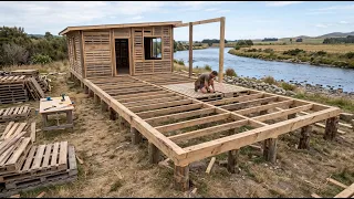 This man is building an incredible house out of wooden pallets all by himself on the riverbank!