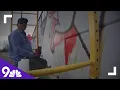 Artist painting mural by Arvada Post Office