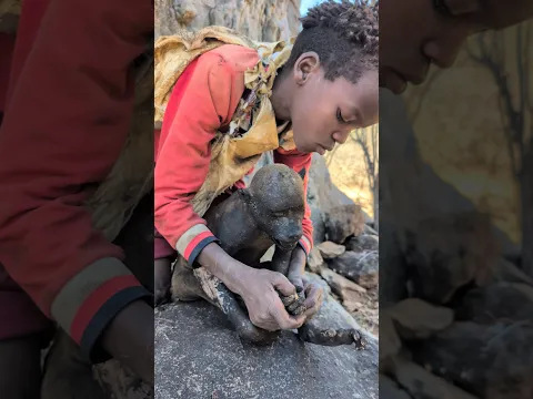 Young boy enjoying a traditional baboon meal — an incredible food experience!