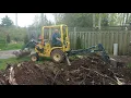 Terramite T5C Mini Backhoe Loader Excavator in action removing stumps and grading land