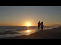 Young couple walking along beach in sunset holding hands - Free Footage